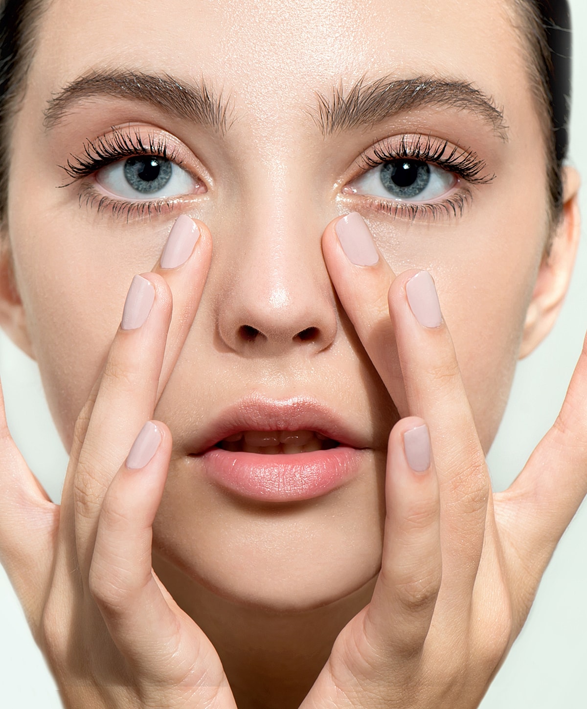 Close-up of a woman applying skincare to her face.