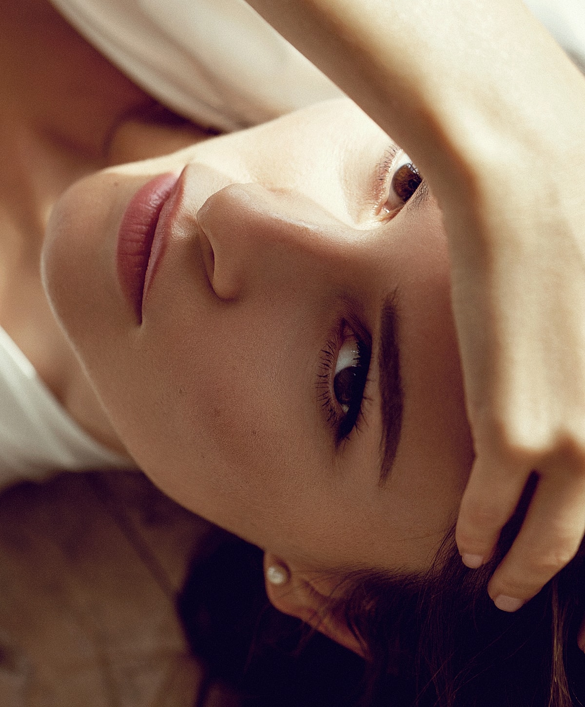 Close-up of a woman with hand on forehead.
