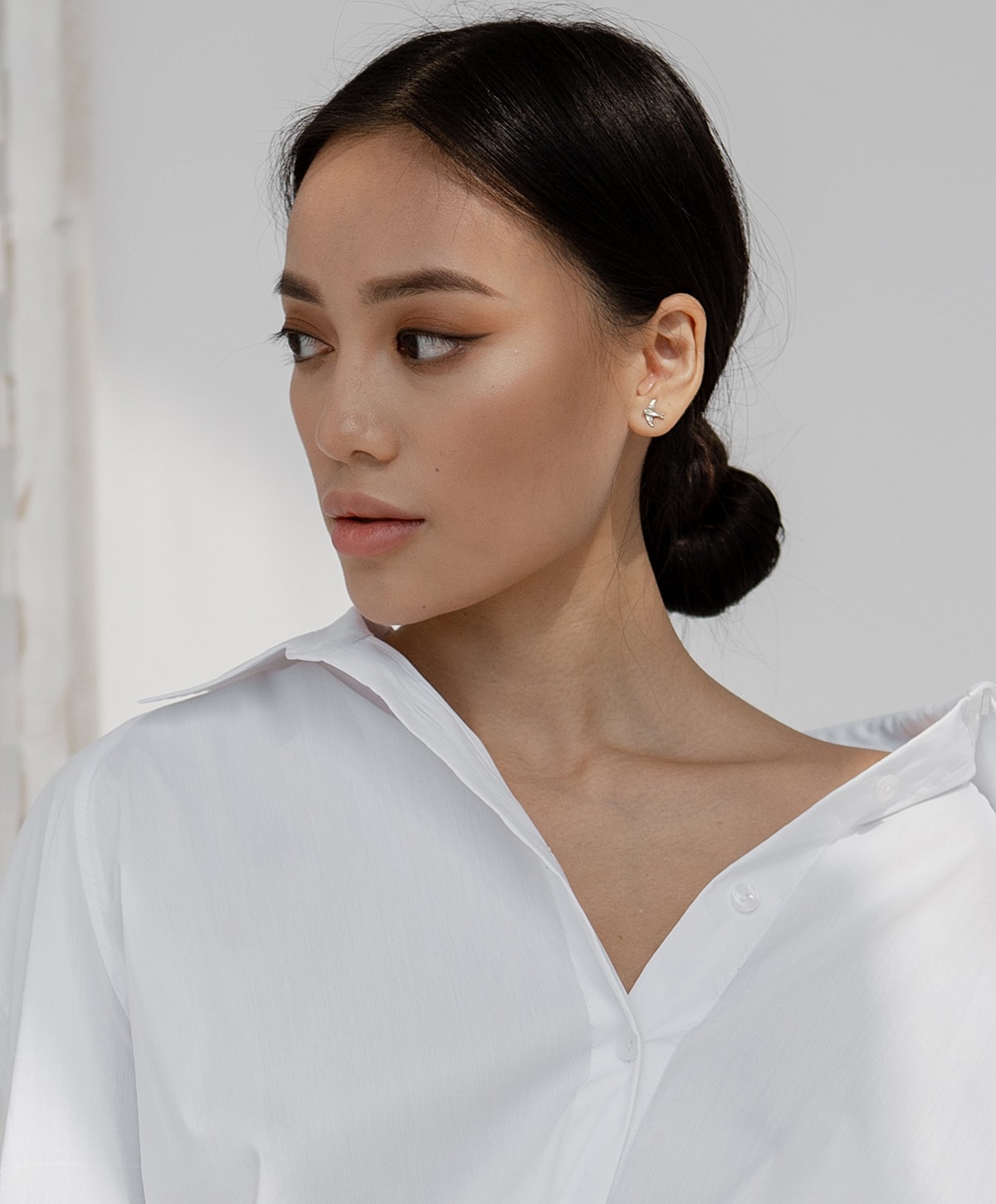 Woman in a white shirt, looking to side.