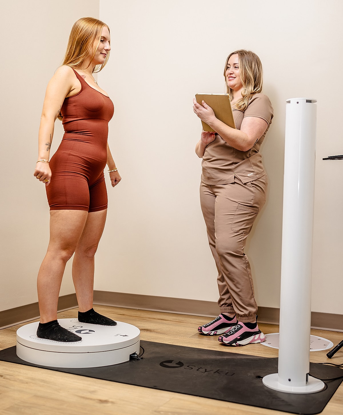 Woman weighing in with healthcare professional present.