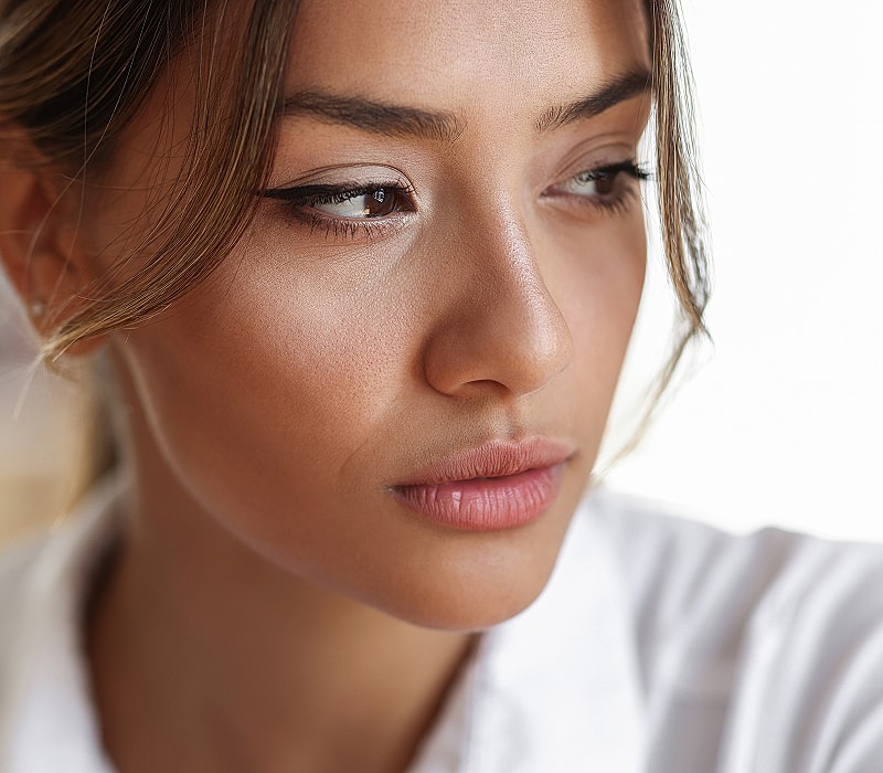 Close-up portrait of a thoughtful young woman.