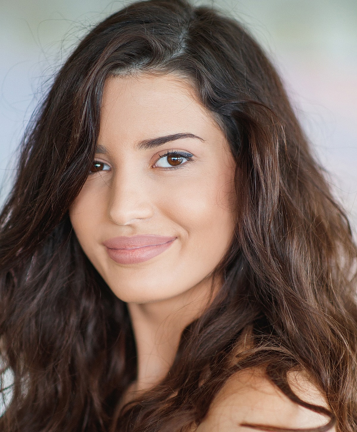 Woman with long, wavy hair smiling softly.