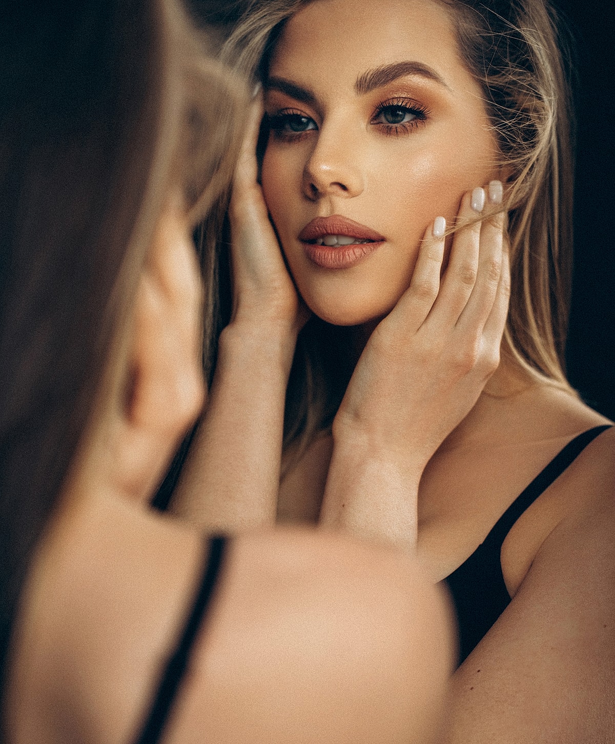 Woman admiring her reflection in a mirror.