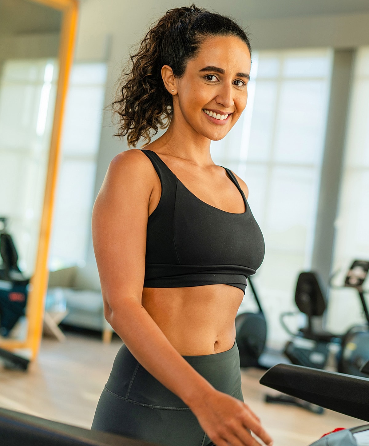 Smiling woman in athletic wear at gym.