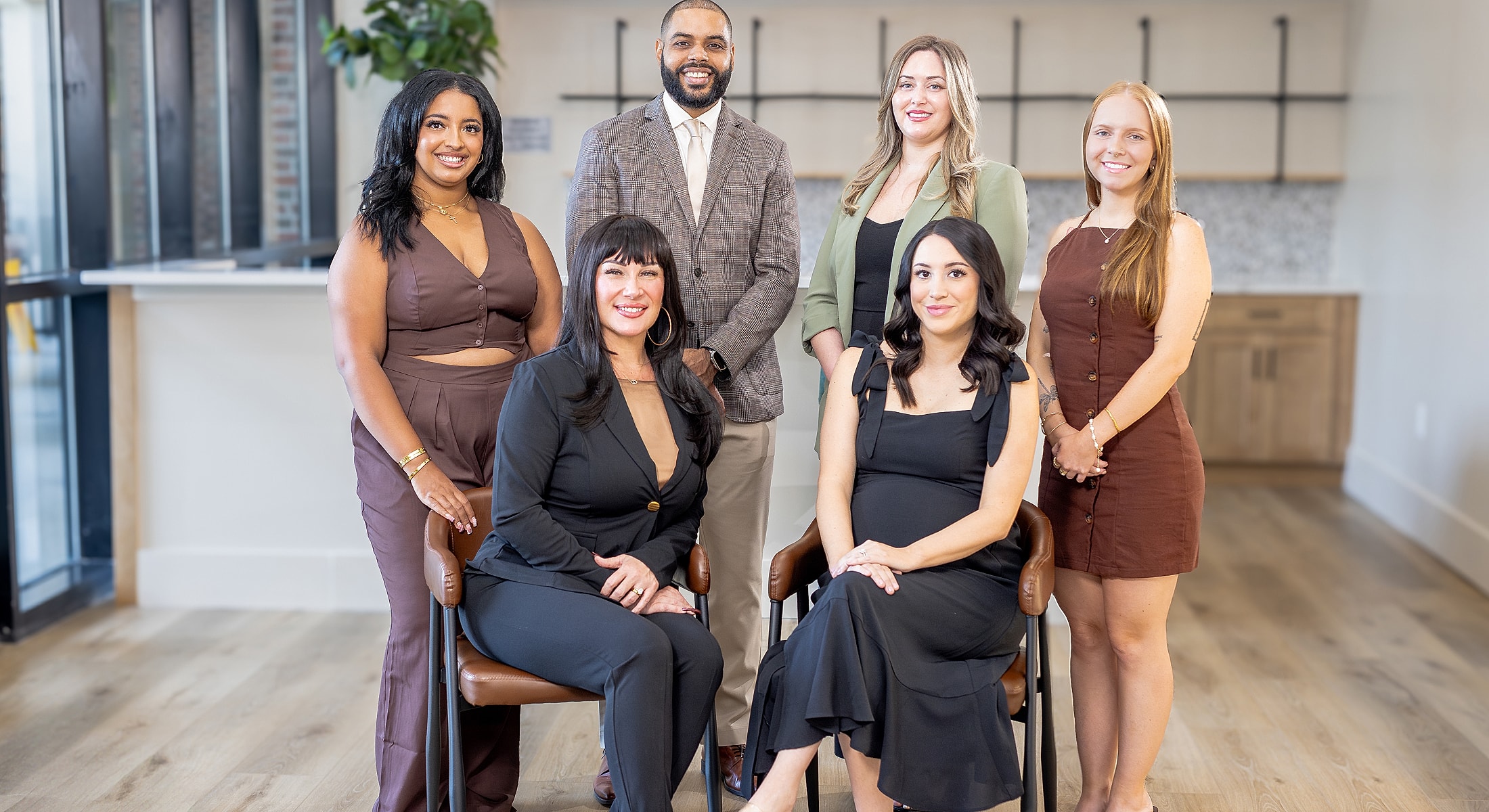 Diverse group portrait in modern office setting.